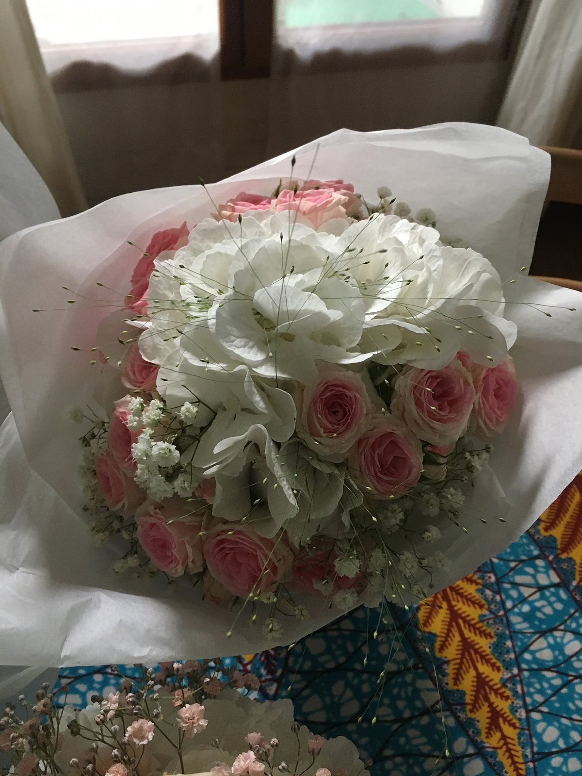 Bouquet d’hortensia blanc et de roses pâles dans son papier